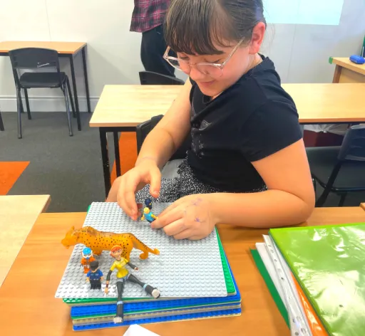 girl drawing pictured with figurines in a stop motion film class