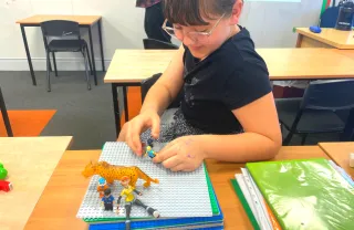 girl drawing pictured with figurines in a stop motion film class