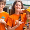 kids holding robots wearing orange tshirts