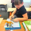 girl drawing pictured with figurines in a stop motion film class