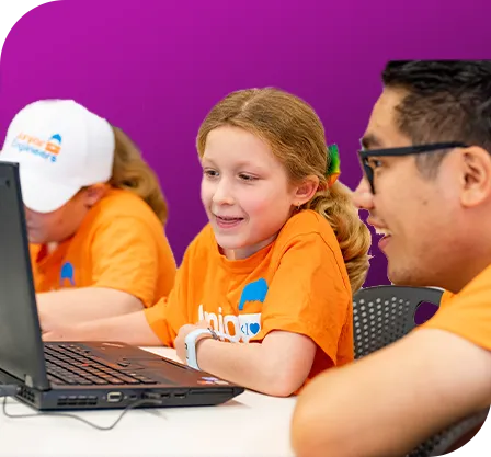 Junior Engineers instructor teaches coding to two young girls