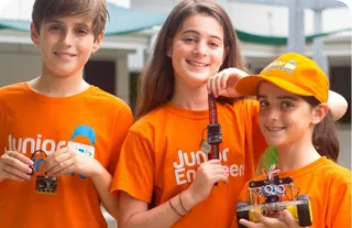 kids holding robots wearing orange tshirts